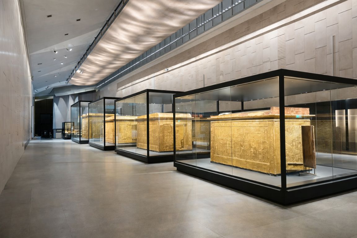 Tutankhamun gallery with golden sarcophagi displayed inside the Grand Egyptian Museum during a tour with The Grand Egyptian Museum Tickets
