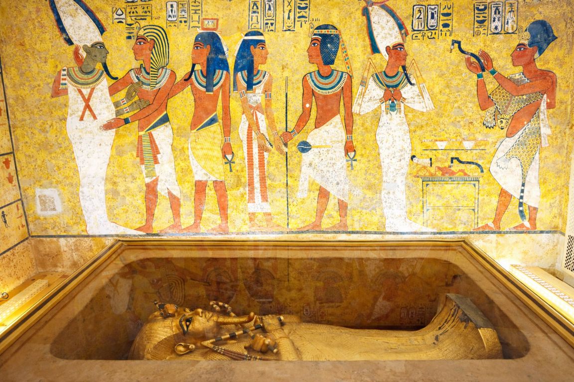 Golden sarcophagus of Tutankhamun inside a reconstructed tomb setting with detailed hieroglyphics visited with The Grand Egyptian Museum Tickets